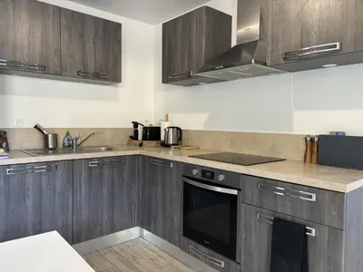 a kitchen with wooden cabinets and a stove top oven at Le Bettex - Lumineux - Vue montagne in Saint-Gervais-les-Bains