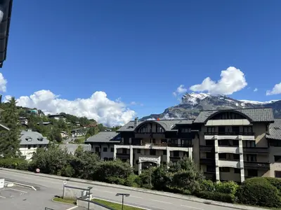 a building next to a road with a mountain at Le Bettex - Lumineux - Vue montagne in Saint-Gervais-les-Bains