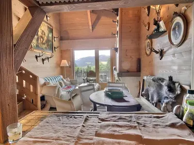 a living room with a table and chairs in a room at Appartement de standing Mont d'Arbois in Megève