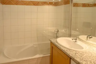 a bathroom with a tub and a sink and a bath tub at Le Névé in Saint-Gervais-les-Bains