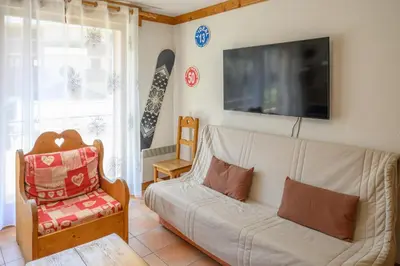 a living room with a couch and a snowboard on the wall at Le Névé in Saint-Gervais-les-Bains