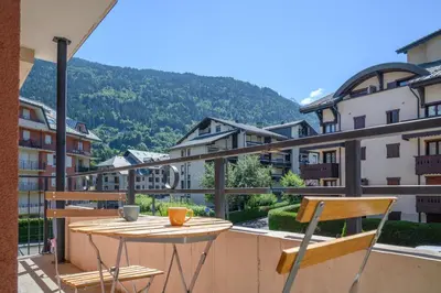 a table and chairs on a balcony with a view at Le Névé in Saint-Gervais-les-Bains