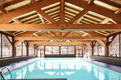 an indoor swimming pool with a large wooden ceiling at Charming Apartment Chamonix Valley in Vallorcine