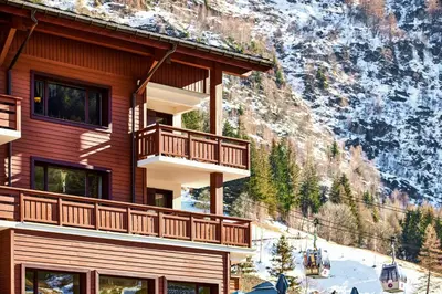 a building with balconies on the side of a mountain at Charming Apartment Chamonix Valley in Vallorcine