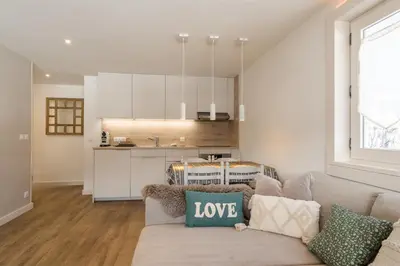 a living room with a couch and a kitchen at Flat La Loge - At the foot of the Jaillet in Megève in Megève