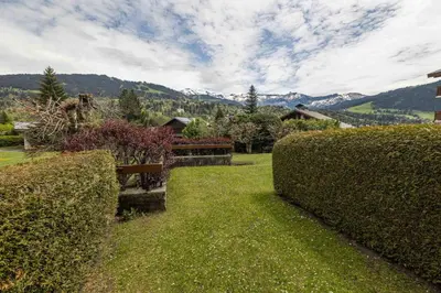 a park with hedges and a bench in the grass at Flat La Loge - At the foot of the Jaillet in Megève in Megève