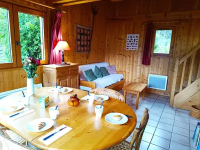 a wooden dining room with a table and a couch at Le Mazot des Tacounets in Saint-Gervais-les-Bains
