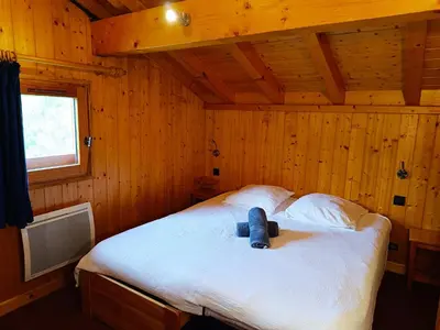 a bedroom with a bed with a teddy bear on it at Le Mazot des Tacounets in Saint-Gervais-les-Bains
