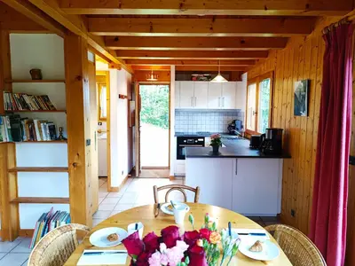 a kitchen with a wooden table with flowers on it at Le Mazot des Tacounets in Saint-Gervais-les-Bains