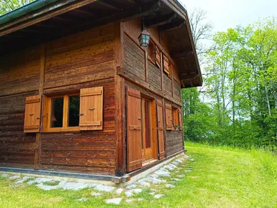 a wooden house with windows on a field at Le Mazot des Tacounets in Saint-Gervais-les-Bains