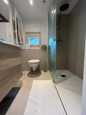 a bathroom with a toilet and a glass shower at Residence VARLOPE in Chamonix-Mont-Blanc