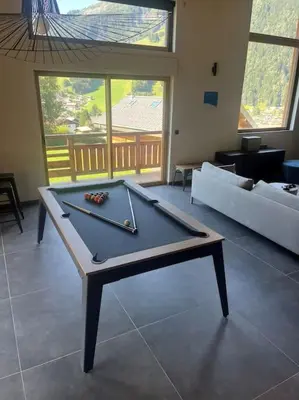 a ping pong table in a living room with a couch at Chalet mitoyen - Jacuzzi - Cousinade I in Les Contamines-Montjoie