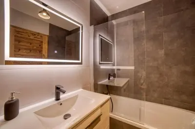 a bathroom with a sink and a mirror and a tub at Chalet mitoyen - Jacuzzi - Cousinade I in Les Contamines-Montjoie