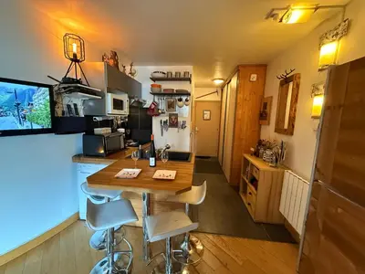 a kitchen with a table and chairs in a room at CHAMONIX Centre - Studio de charme avec parking, Vue sur le Mont-Blc in Chamonix-Mont-Blanc