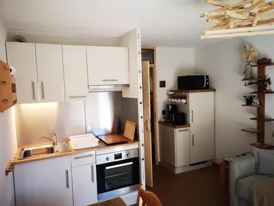 a small kitchen with white cabinets and a sink at Chamonix, studio de 24 m2 in Chamonix-Mont-Blanc
