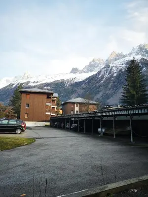 a parking lot with snow covered mountains in the background at Chamonix, studio de 24 m2 in Chamonix-Mont-Blanc
