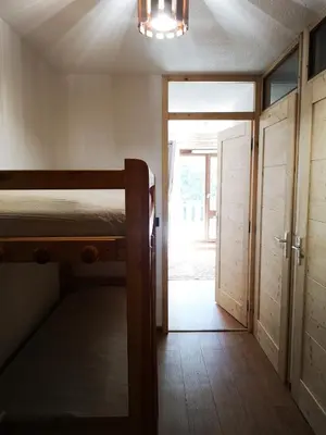 a bedroom with a bunk bed and a sliding door at Chamonix, studio de 24 m2 in Chamonix-Mont-Blanc