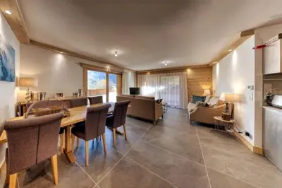 a dining room with a table and chairs and a couch at MGM Charles Delys - 3 Rooms - Les Houches in Les Houches