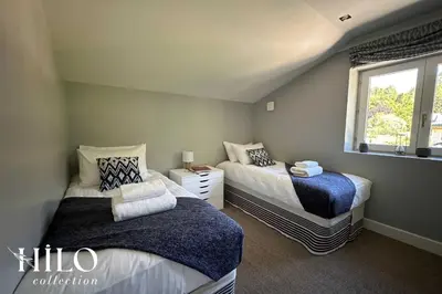 a bedroom with two beds and a window at Chalet La Moraine Chamonix Mont Blanc by HILO Collection - 8 people - Jacuzzi and PS5 in Chamonix-Mont-Blanc