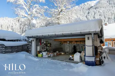a shop covered in snow with snow on the roof at Chalet La Moraine Chamonix Mont Blanc by HILO Collection - 8 people - Jacuzzi and PS5 in Chamonix-Mont-Blanc