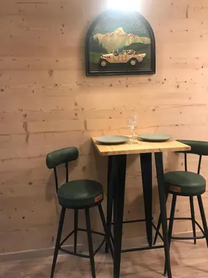 a table with two chairs and a car picture on the wall at STUDIO DENT DU CROCODILE, AIGUILLE du MIDI, BALCON, PARKING in Chamonix-Mont-Blanc