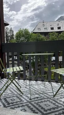 a black bench with a table on a patio at STUDIO DENT DU CROCODILE, AIGUILLE du MIDI, BALCON, PARKING in Chamonix-Mont-Blanc