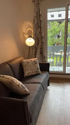 a living room with a couch and a window at STUDIO DENT DU CROCODILE, AIGUILLE du MIDI, BALCON, PARKING in Chamonix-Mont-Blanc