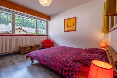 a bedroom with a large bed and a piano at In the center of Chamonix with views of Mont Blanc in Chamonix-Mont-Blanc