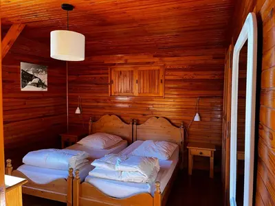 a bedroom with two beds in a wooden cabin at Chalet La Ponote in Samoëns