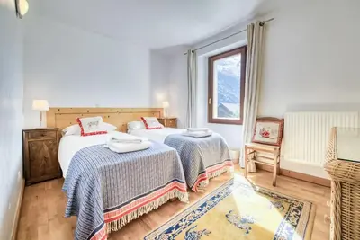 a bedroom with two beds and a window at Chalet L'Argoat - Warm and cosy 6 bedroom chalet in Chamonix-Mont-Blanc