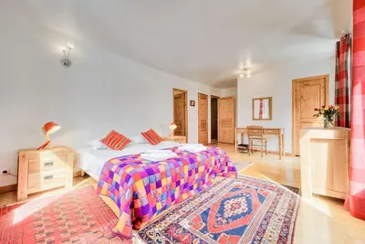 a bedroom with a bed and a table in a room at Chalet L'Argoat - Warm and cosy 6 bedroom chalet in Chamonix-Mont-Blanc
