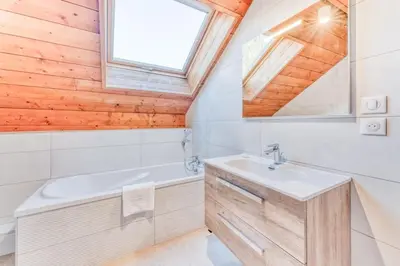 a bathroom with a sink and a tub and a window at Chalet L'Argoat - Warm and cosy 6 bedroom chalet in Chamonix-Mont-Blanc