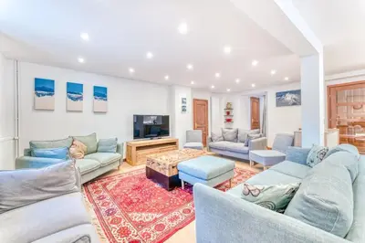a living room with blue couches and a tv at Chalet L'Argoat - Warm and cosy 6 bedroom chalet in Chamonix-Mont-Blanc