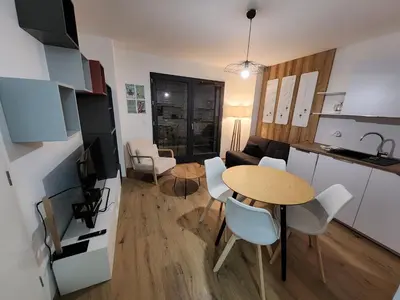 a kitchen and a living room with a table and chairs at Appartement proche télécabine in Saint-Gervais-les-Bains