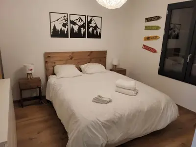 a bedroom with a white bed with two towels on it at Appartement proche télécabine in Saint-Gervais-les-Bains