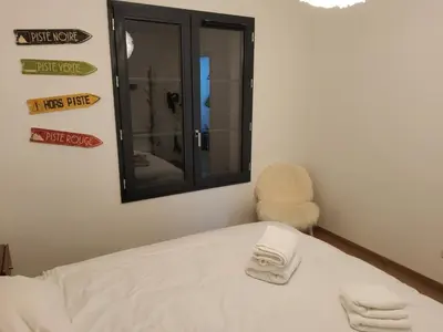 a room with a bed with a mirror and a chair at Appartement proche télécabine in Saint-Gervais-les-Bains