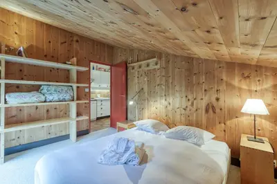 a bedroom with wooden walls and a large bed at Appartement Le Grenier - Happy Rentals in Chamonix-Mont-Blanc