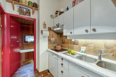 a kitchen with a sink and a red door at Appartement Le Grenier - Happy Rentals in Chamonix-Mont-Blanc