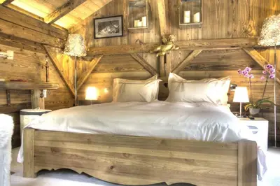 a bedroom with two beds in a log cabin at Hôtel Les Chalets de Philippe avec Jacuzzis Privatifs in Chamonix-Mont-Blanc