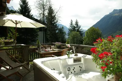 a living room with a red couch and a glass table at Hôtel Les Chalets de Philippe avec Jacuzzis Privatifs in Chamonix-Mont-Blanc