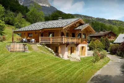 a large wooden house with a mountain in the background at Chalet Anselme - OVO Network in Cordon