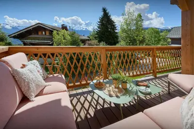 a patio with a couch and a table on a deck at Chalet Anselme - OVO Network in Cordon