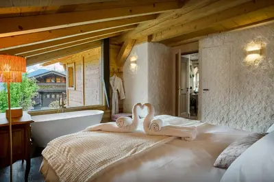 a bedroom with a tub and a bed with towels at Chalet Anselme - OVO Network in Cordon