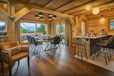 a dining room and kitchen with a table and chairs at Chalet Anselme - OVO Network in Cordon