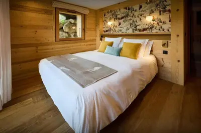 a large white bed in a room with wooden walls at Chalet Anselme - OVO Network in Cordon