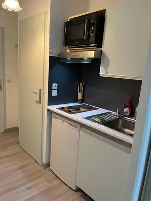 a small kitchen with a sink and a microwave at studio station des carroz d'arraches in Arâches-la-Frasse