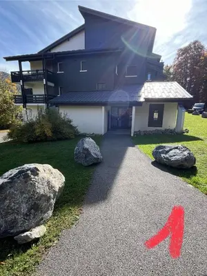 a house with rocks and a red arrow on a driveway at studio station des carroz d'arraches in Arâches-la-Frasse