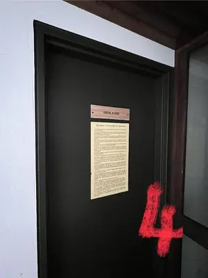 a sign on a black wall with red writing on it at studio station des carroz d'arraches in Arâches-la-Frasse