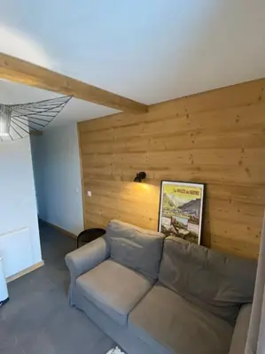 a living room with a couch and a wooden wall at Appartement 4 personnes centre village in Samoëns