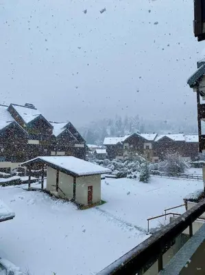 a snow covered yard with houses and buildings at Appartement 4 personnes centre village in Samoëns